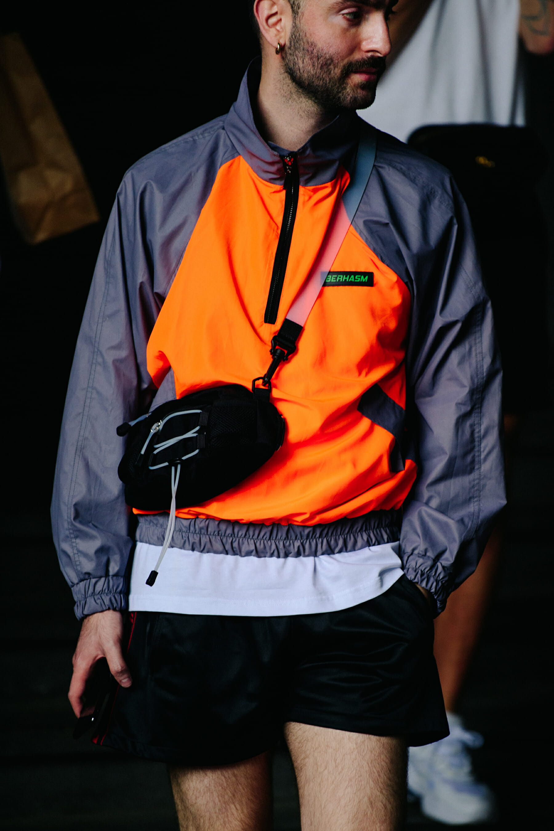 Man wearing orange track top