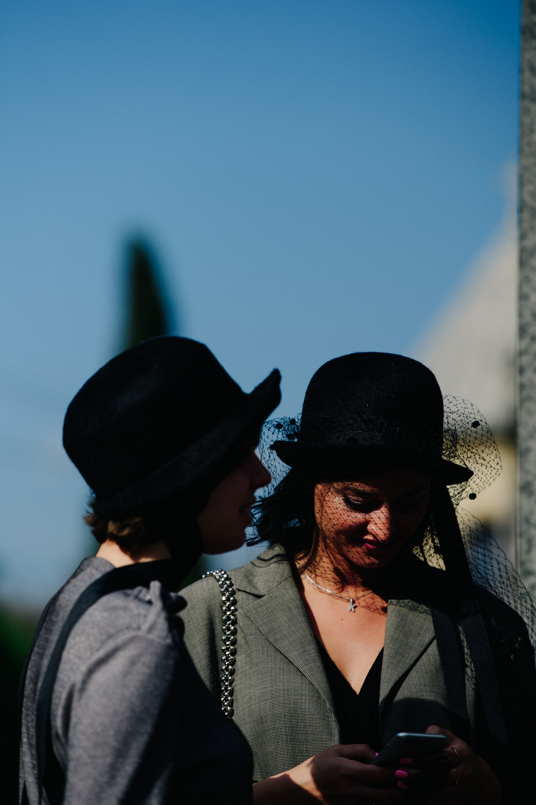 Two women wearing black hats