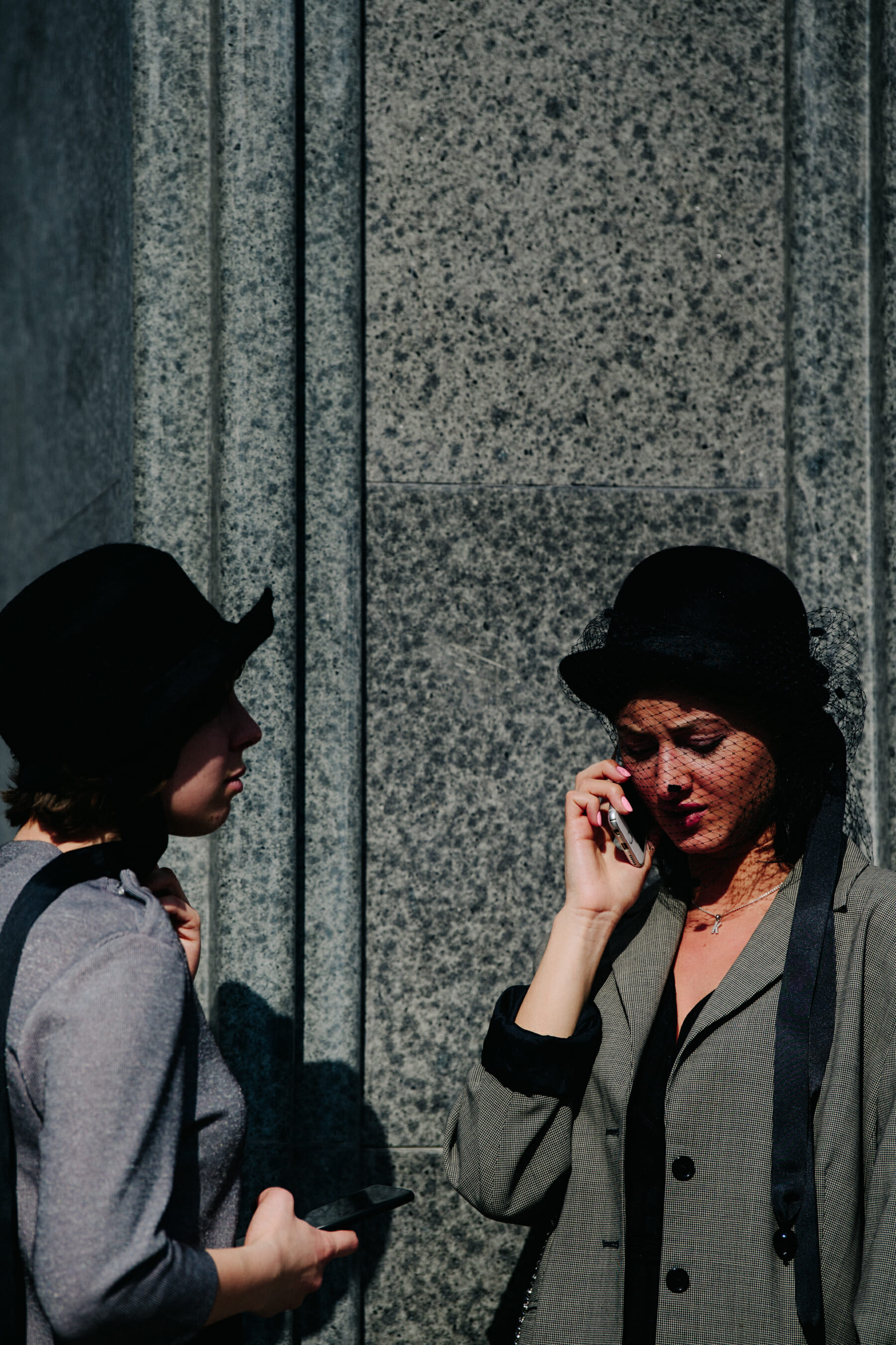 Two women wearing black hats