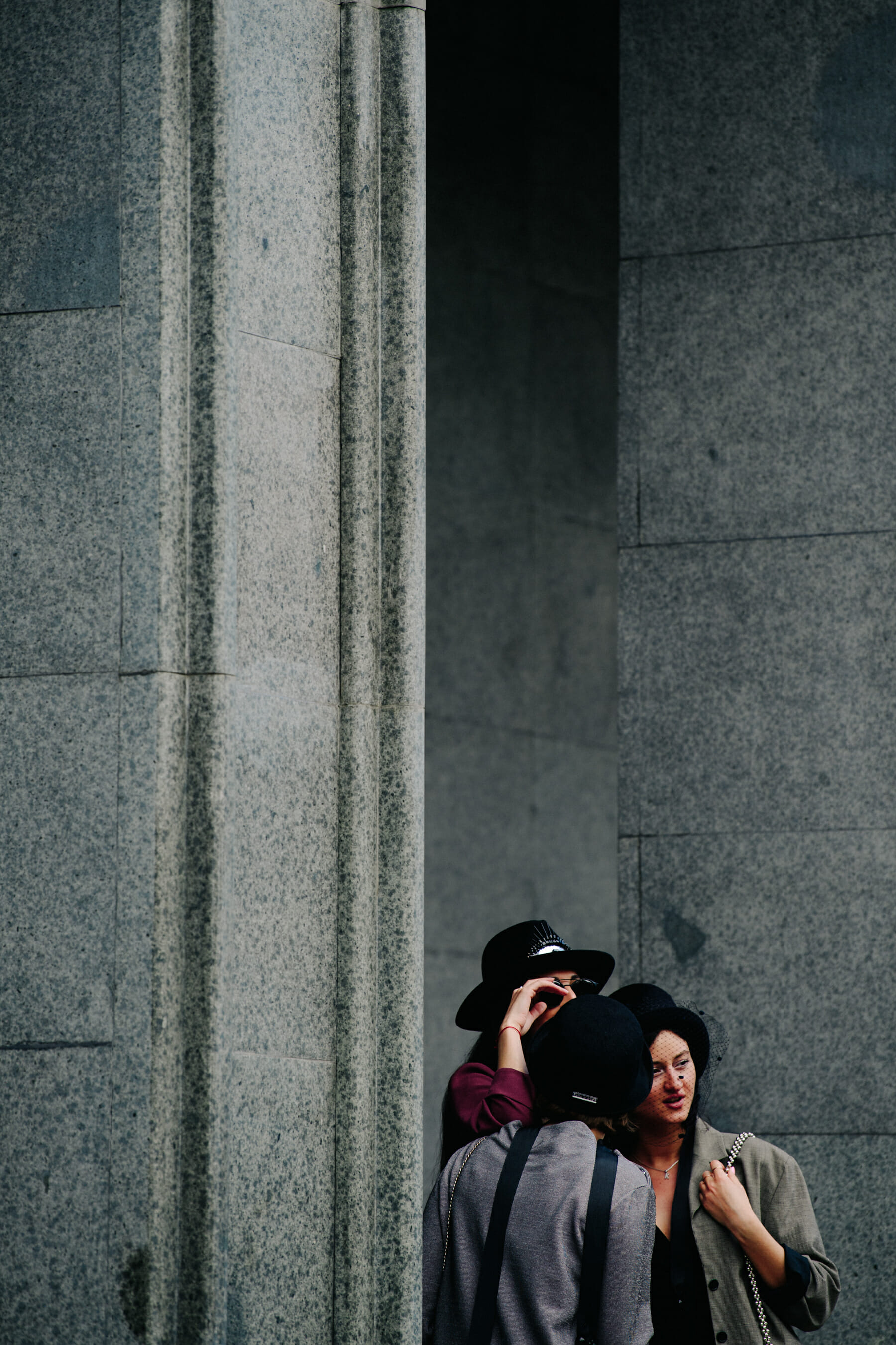 Three women wearing black hats