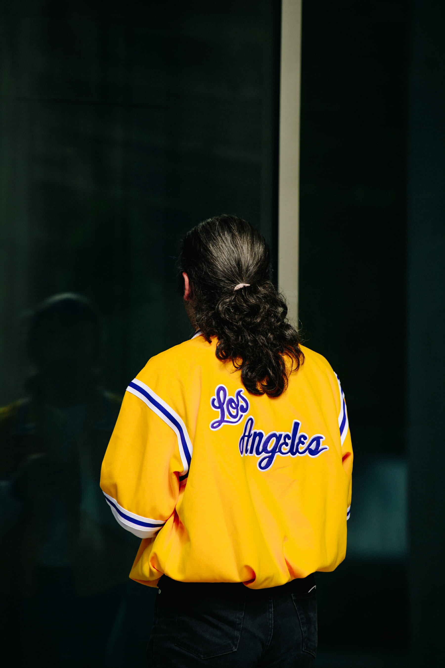 Man wearing yellow baseball jacket
