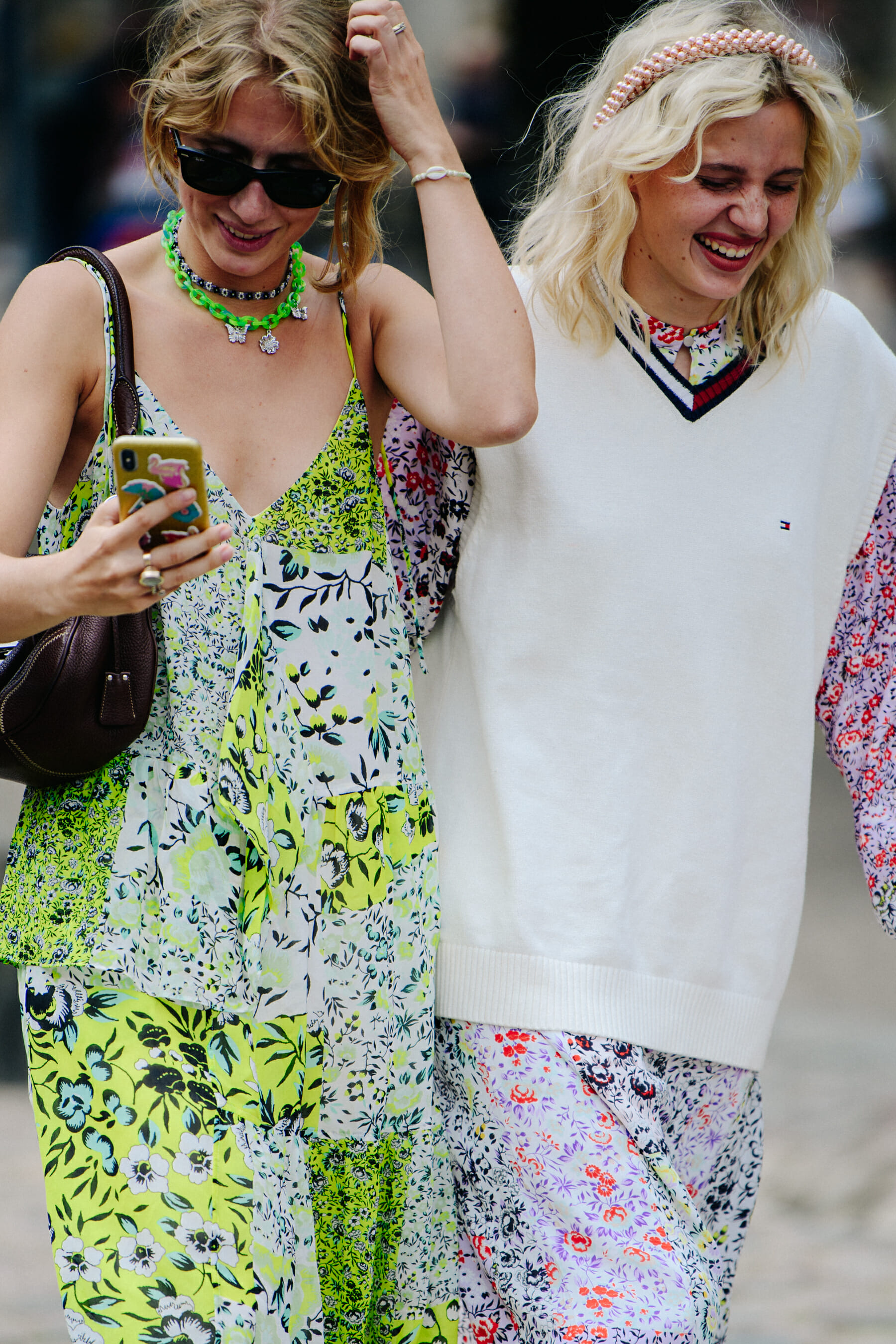 Two women wearing floral dresses