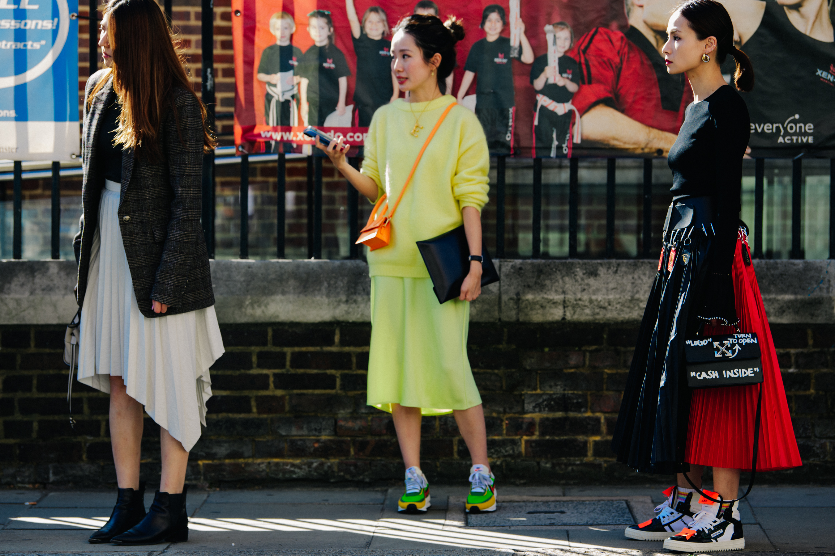 Three women wearing colourful skirts