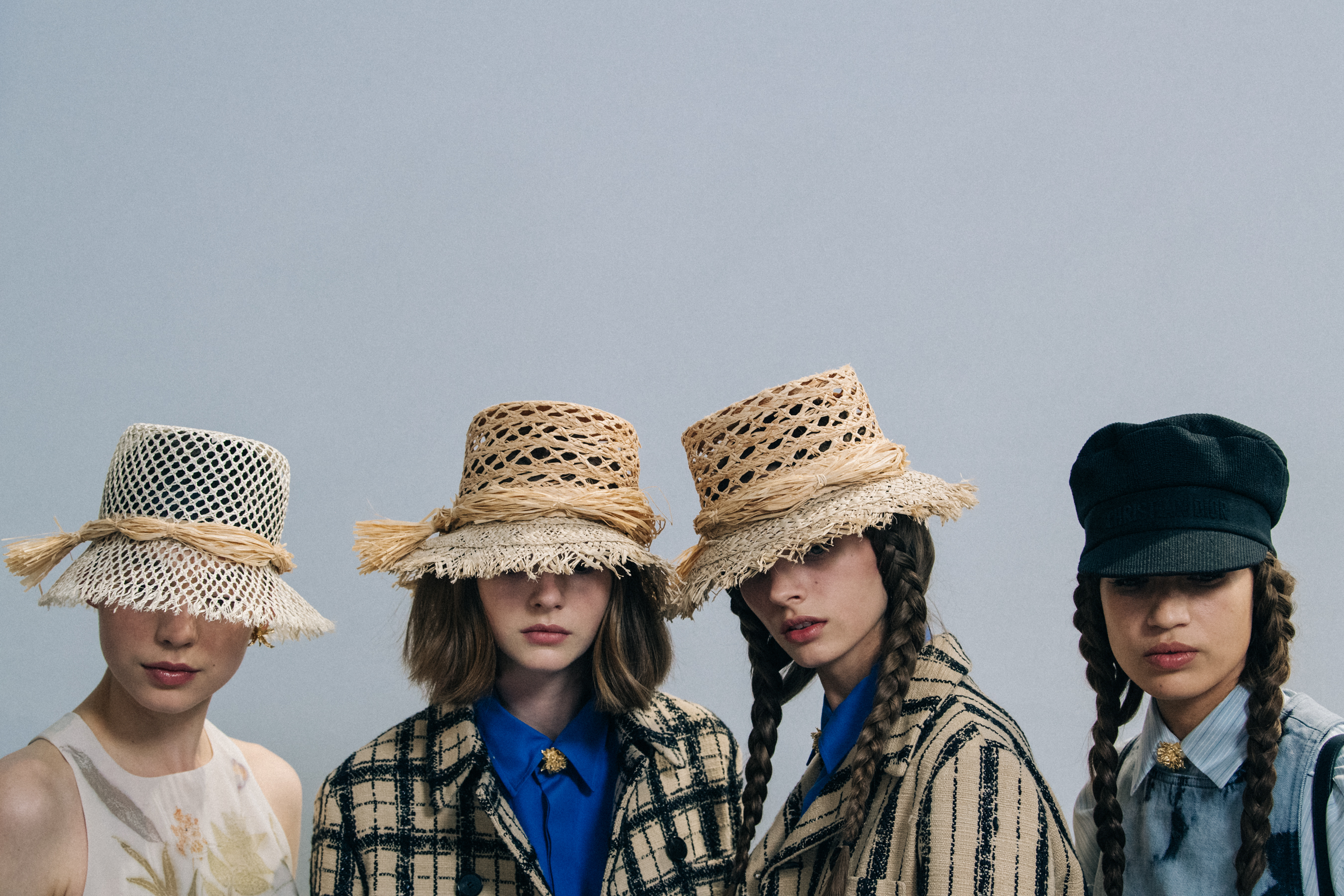 Models wearing straw hats at Christian Dior