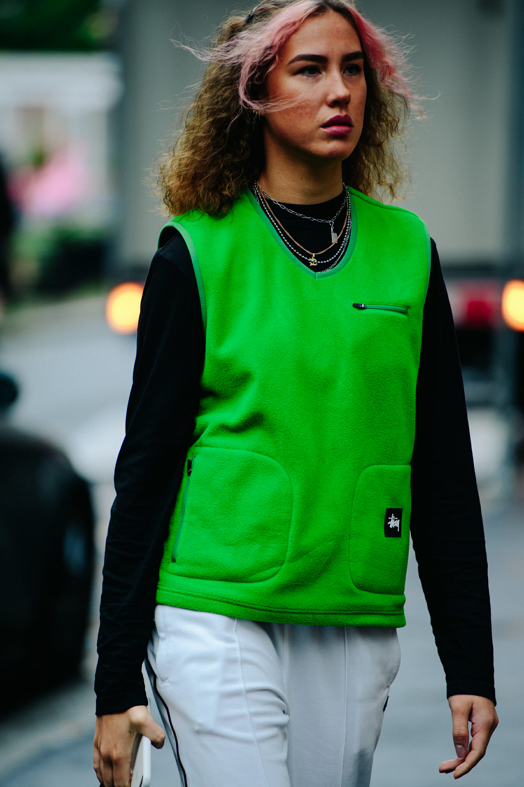 Woman wearing green Stussy vest