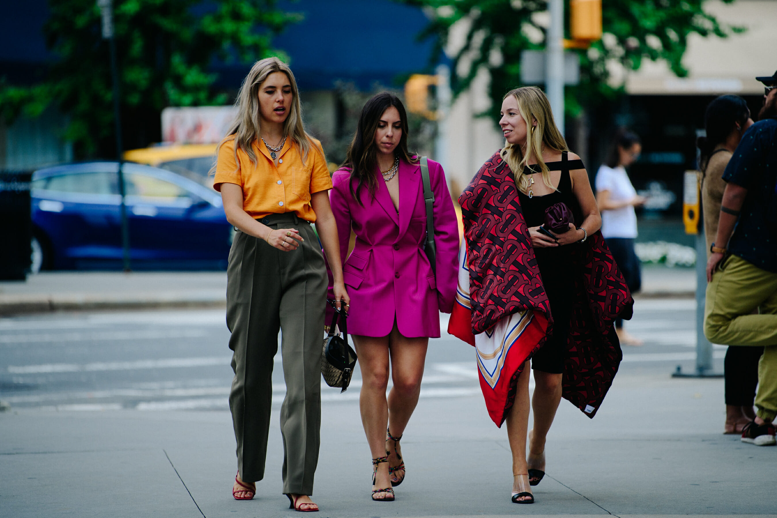 Three women wearing colourful outfits