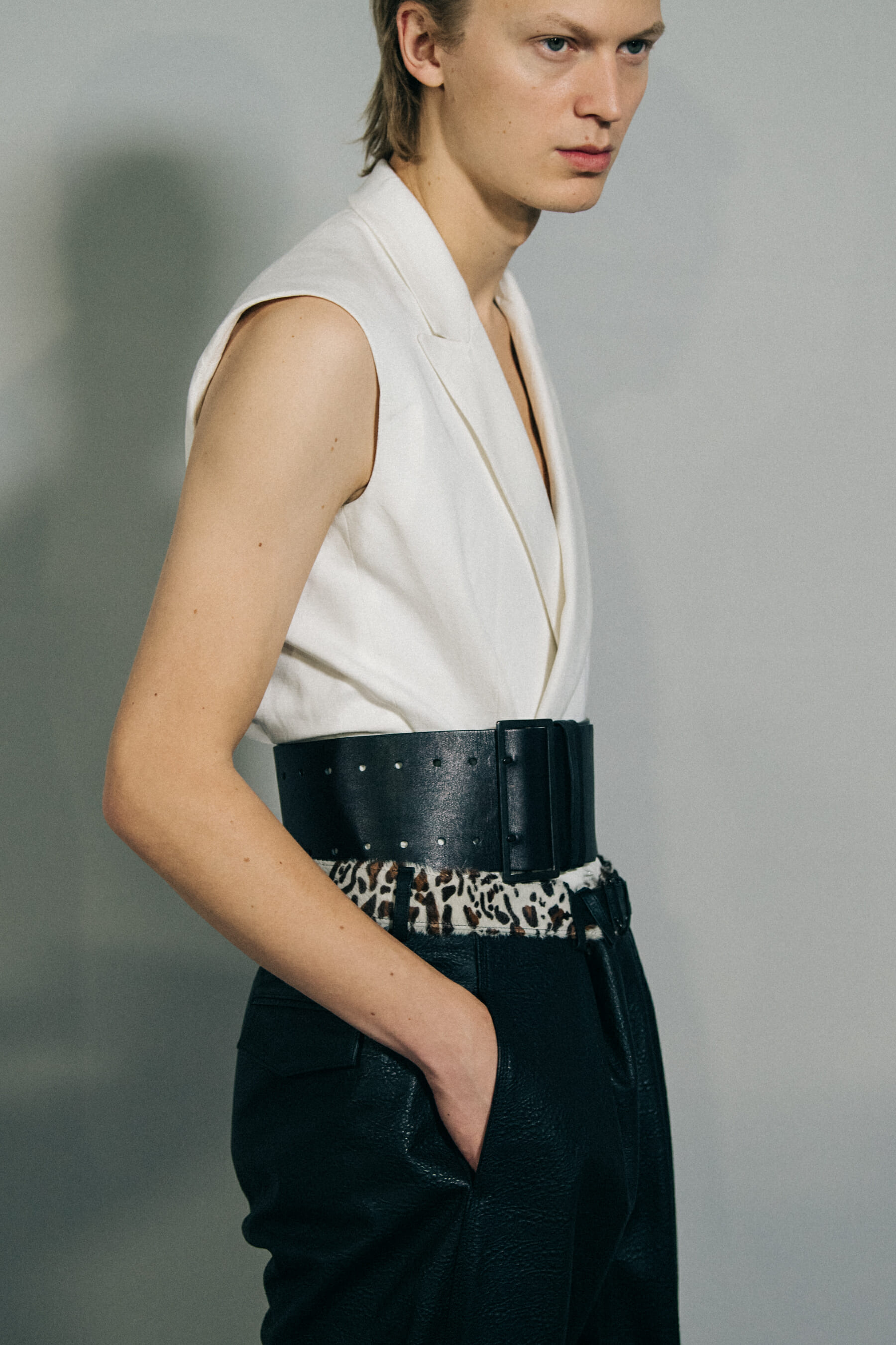 Model wearing white jacket backstage at Haider Ackermann