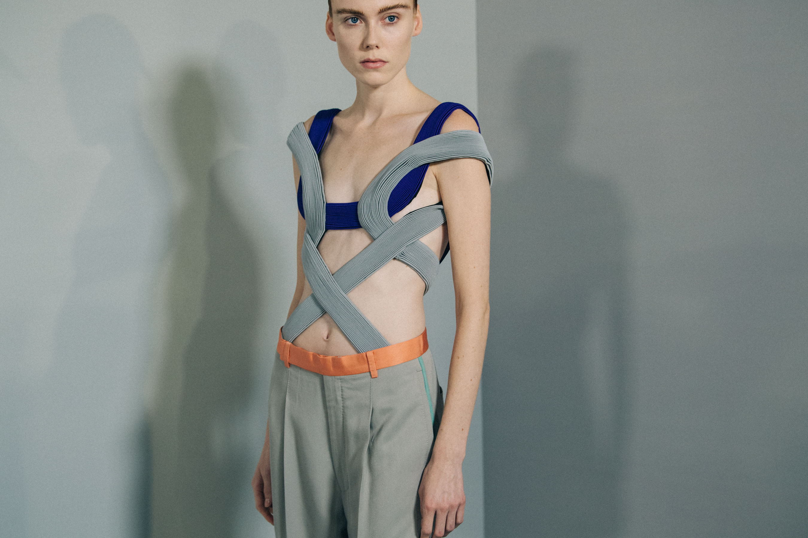 Model backstage wearing grey dress