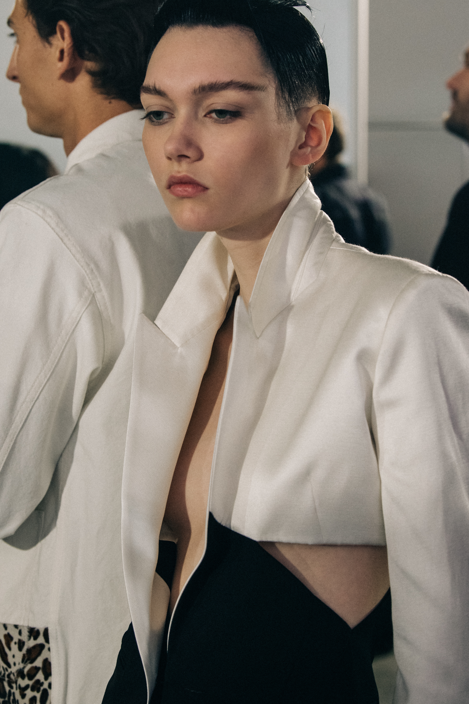 Model wearing white jacket backstage at Haider Ackermann