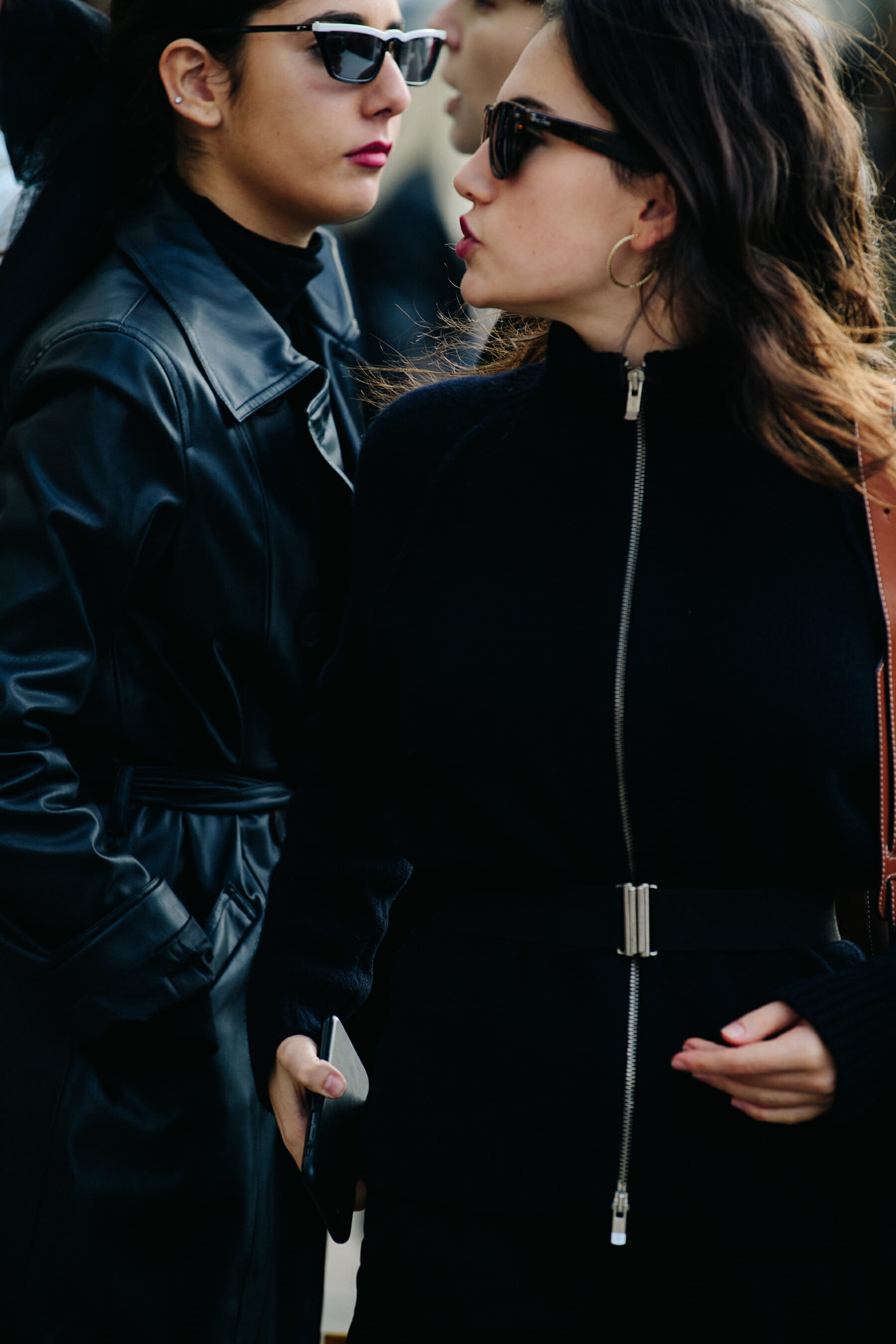 Two women wearing black outfits