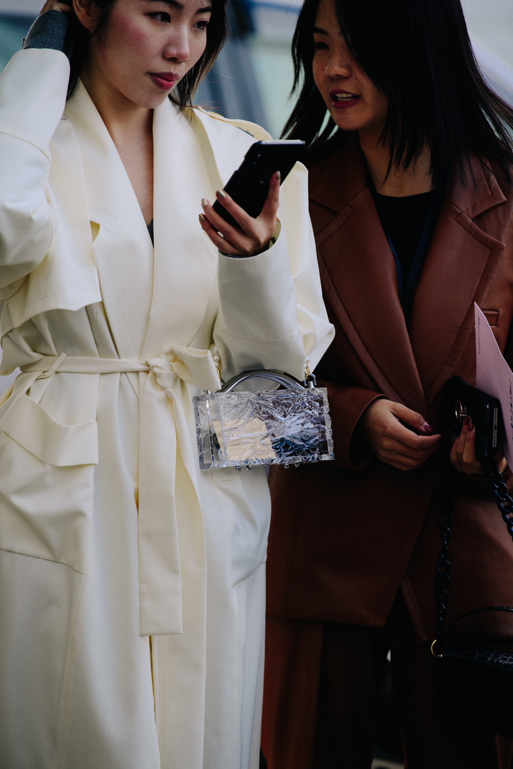 Two women wearing long coats