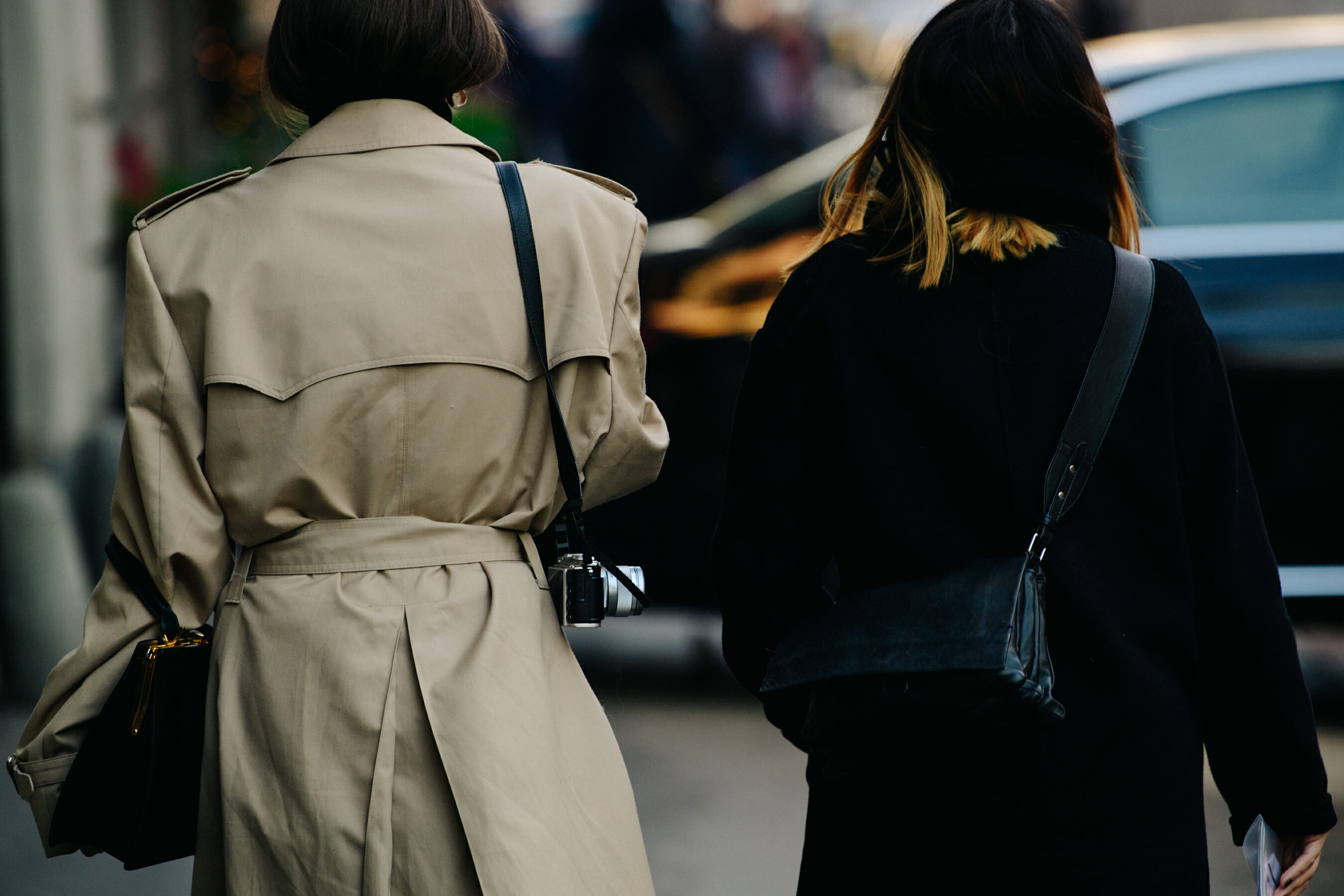 Two women wearing long coats