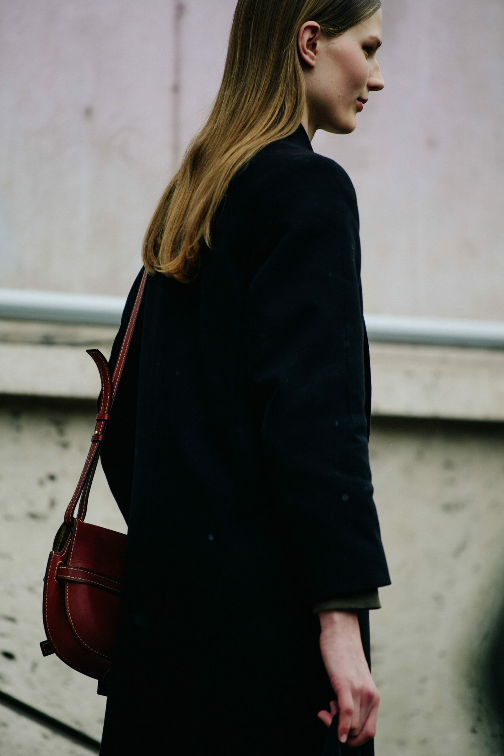 Model carrying brown leather bag