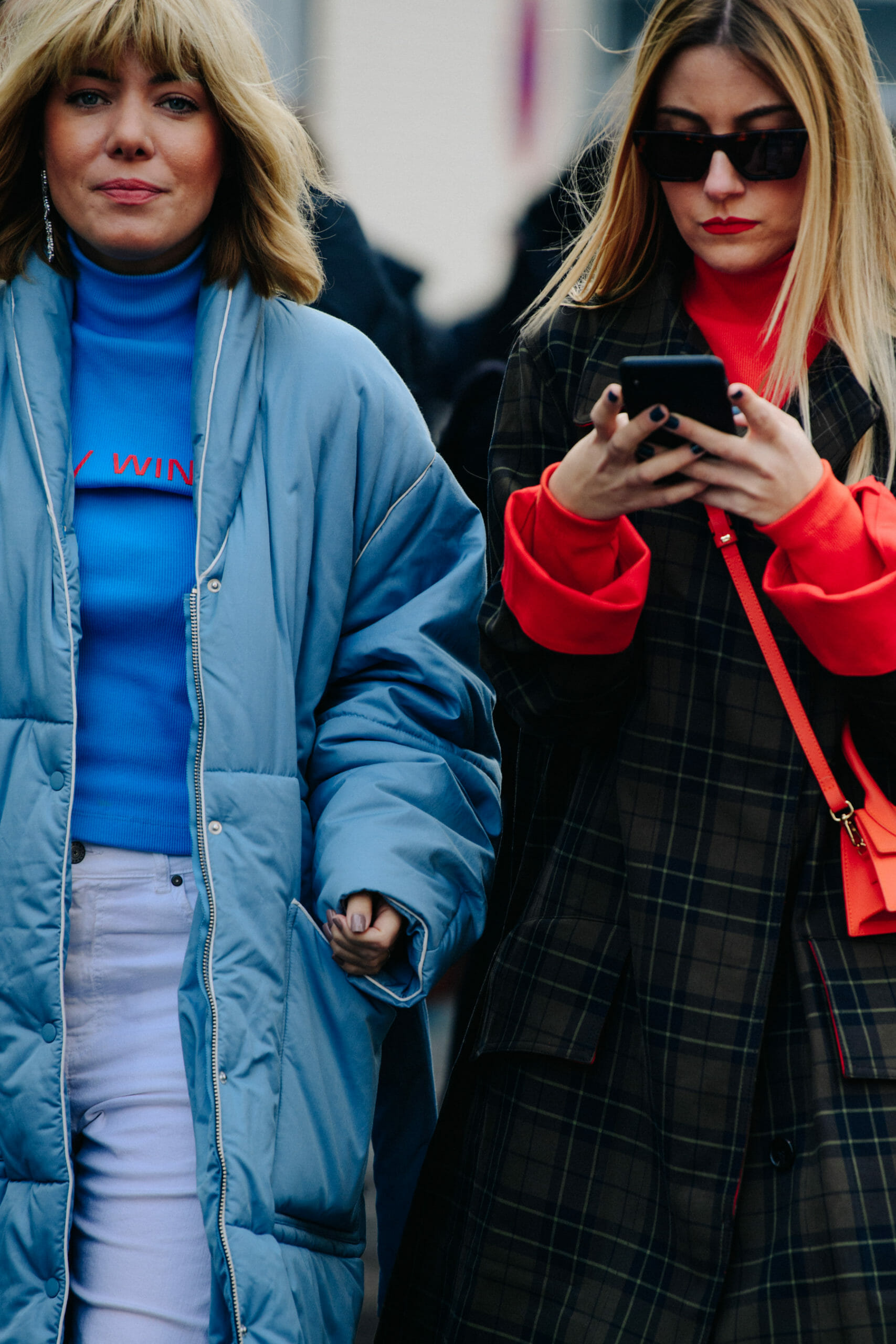 Two women wearing blue and red