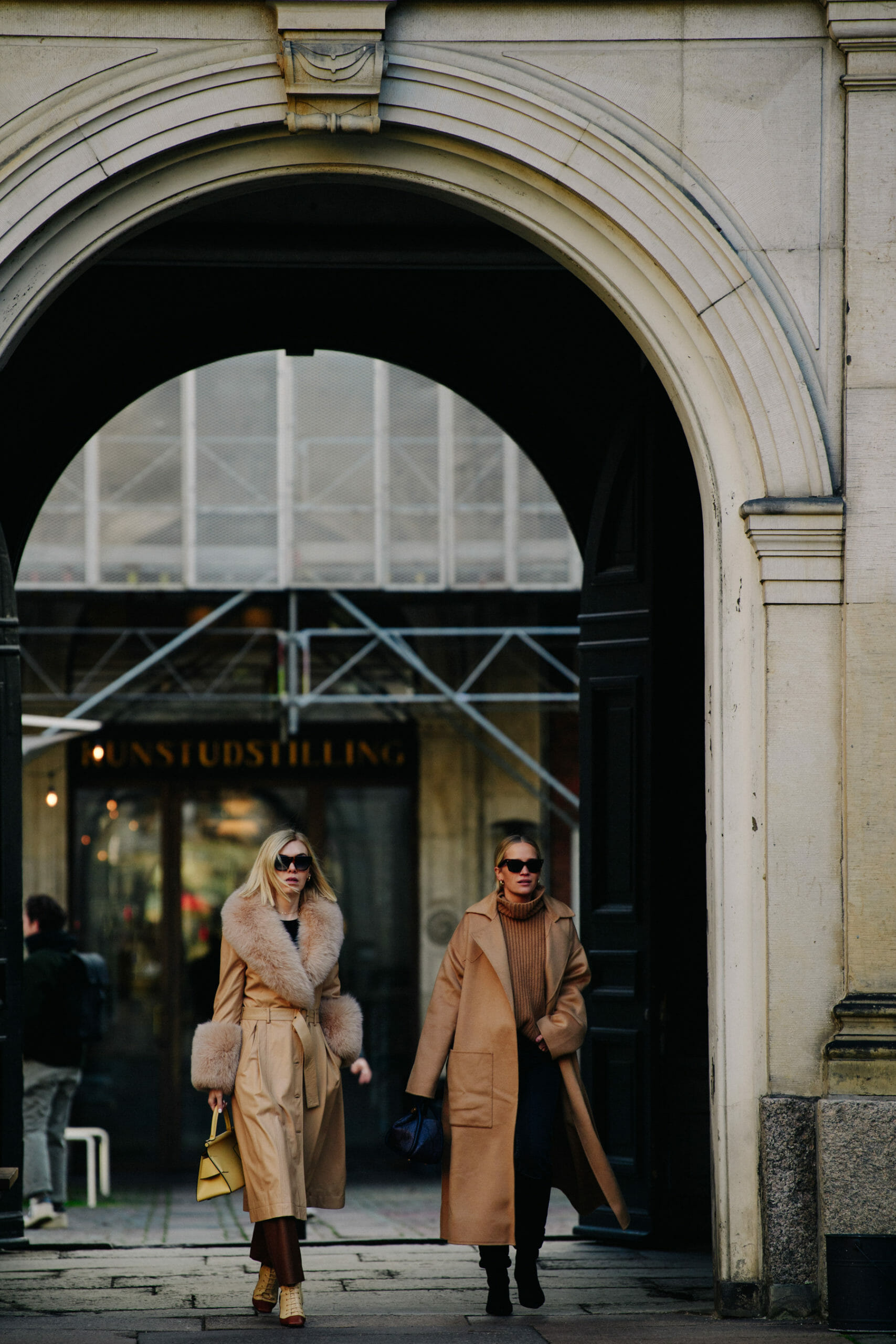 Two women wearing long coats