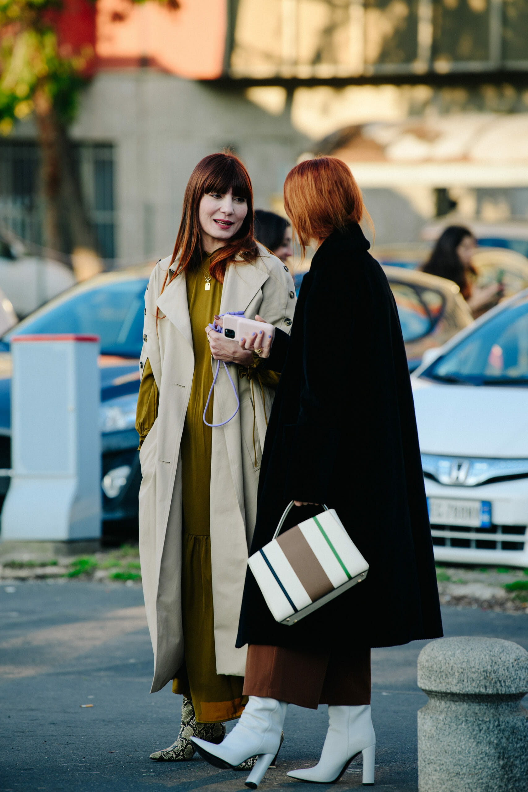 Two women wearing long coats