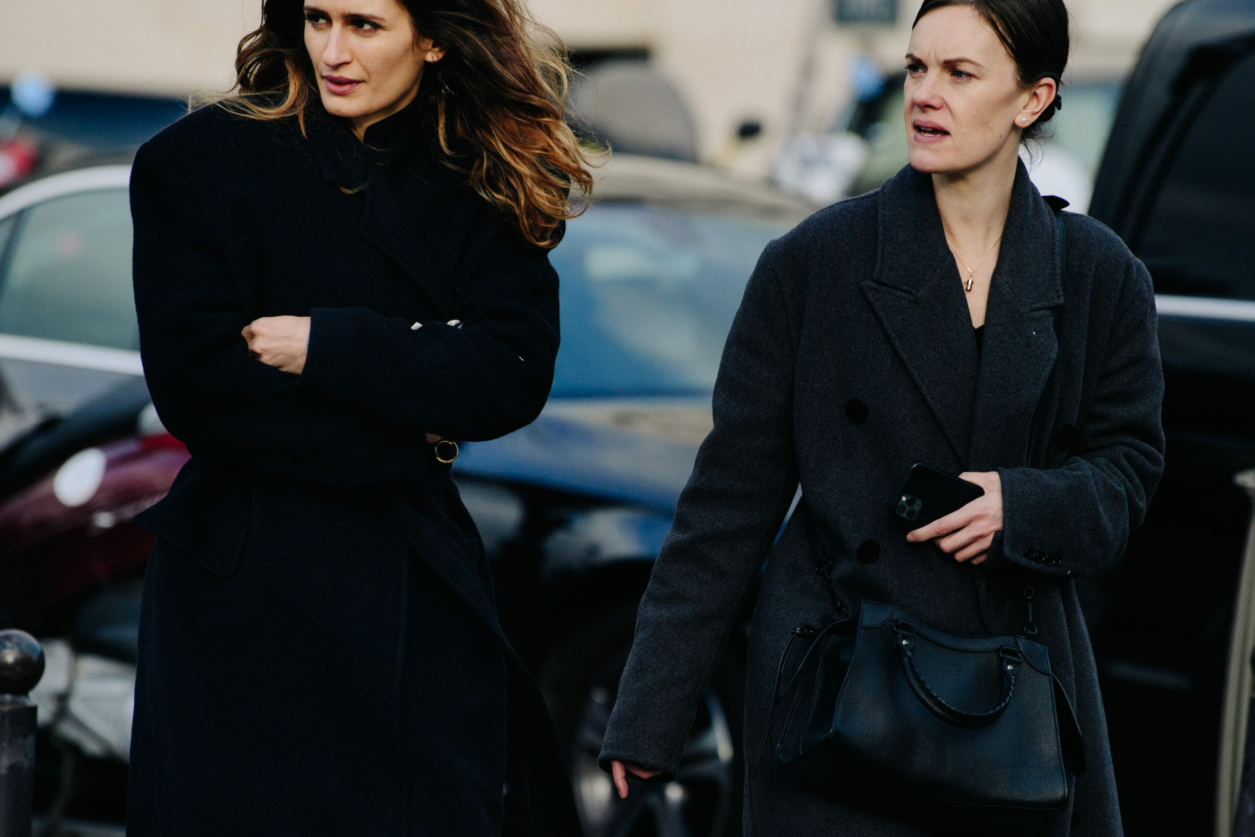 Two women wearing dark outfits